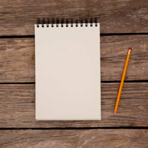 notepad-with-pencil-on-wood-board-background